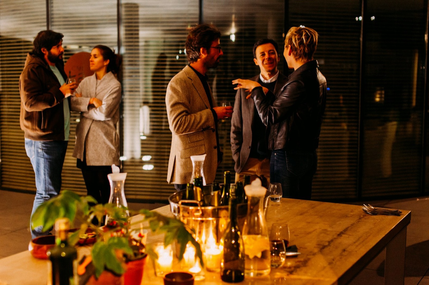 People talking in small groups at an evening networking event
